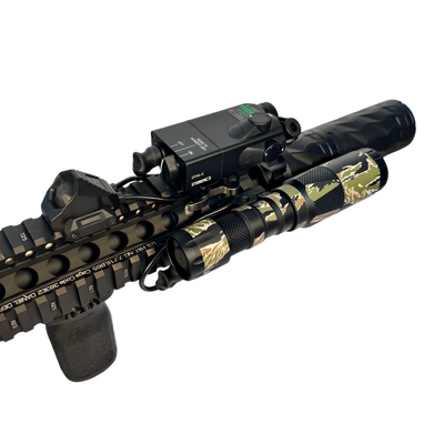 Camouflage rifle with mounted scope and flashlight on a white background